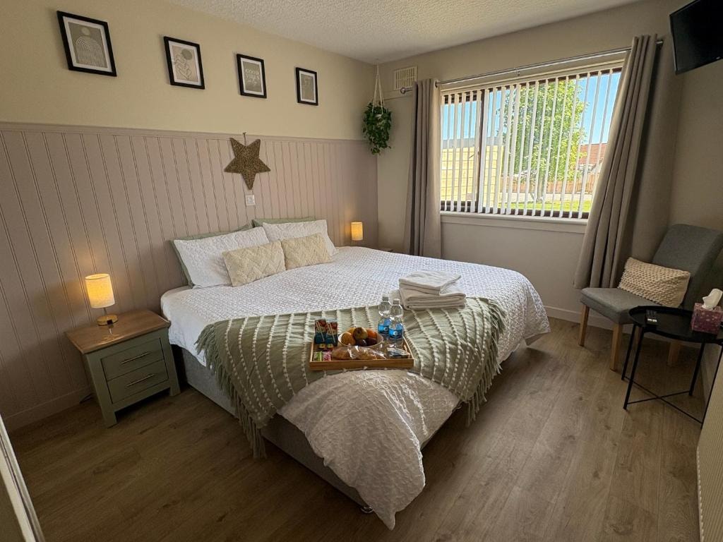 Bedroom with a neatly made bed and refreshments at Carnegie Lodgings