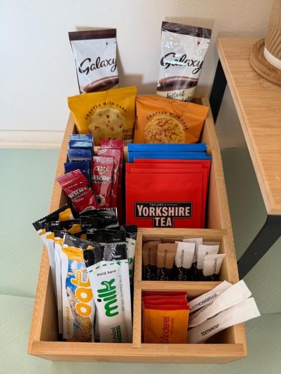 Wooden organiser holding tea, coffee and snacks at Carnegie Lodgings