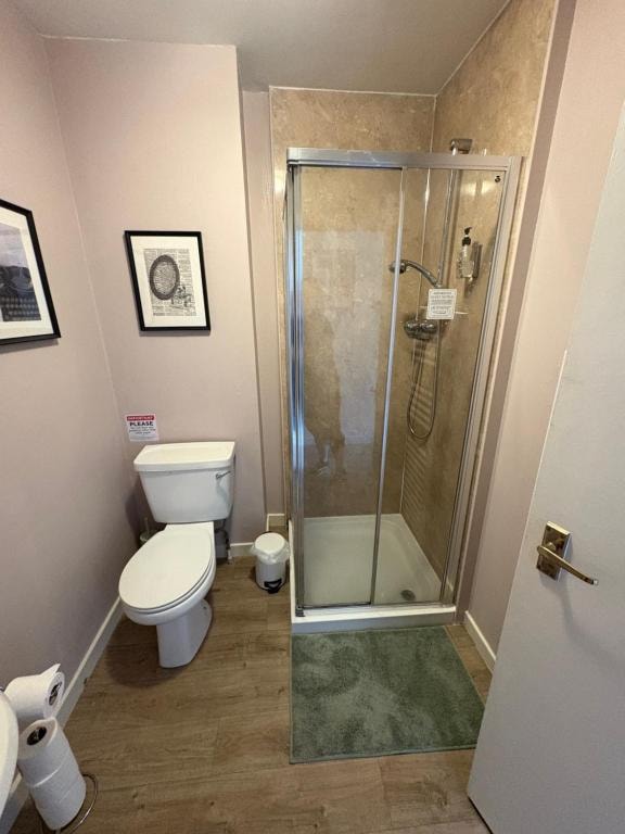 En-suite bathroom with a toilet and glass shower enclosure at Carnegie Lodgings